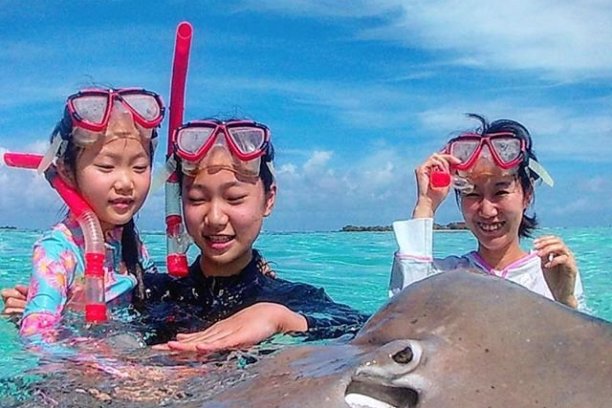 a group of people standing next to a body of water