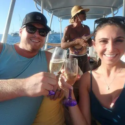 a person drinking water from a wine glass posing for the camera